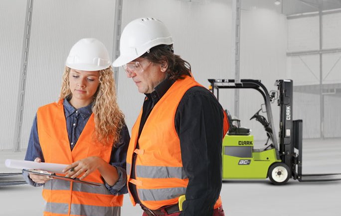 Instructor reviews safety guidelines with forklift operator